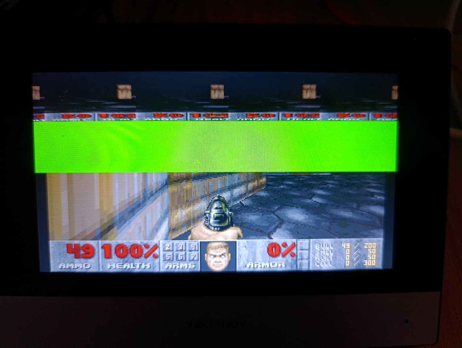 DOOM gameplay running on the panel after being moved by touch controls, tearing artifact visible near the top of the frame